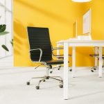 contemporary office chair in home office in front of desk. Room with yellow walls