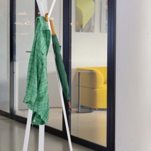 designer coat stand in white in office with green coat hanging on it
