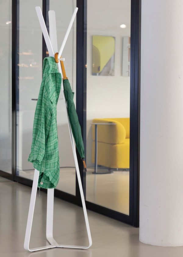 designer coat stand in white in office with green coat hanging on it