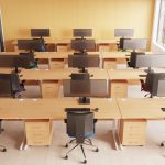 ergonomic medium back office chair in room shot in rows of office desks