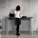 sit - stand desks. Lady standing at height adjustable desk