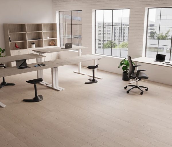 height adjustable sit stand desks room shot with light desk tops and white leg frame. City view out of window