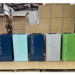 office recycling bins in a row in different colours and lettering to indicate waste stream