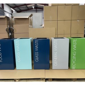 office recycling bins in a row in different colours and lettering to indicate waste stream