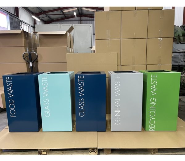office recycling bins in a row in different colours and lettering to indicate waste stream