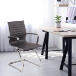 visitor chair grey leather and chrome frame in room shot by trestle style desk