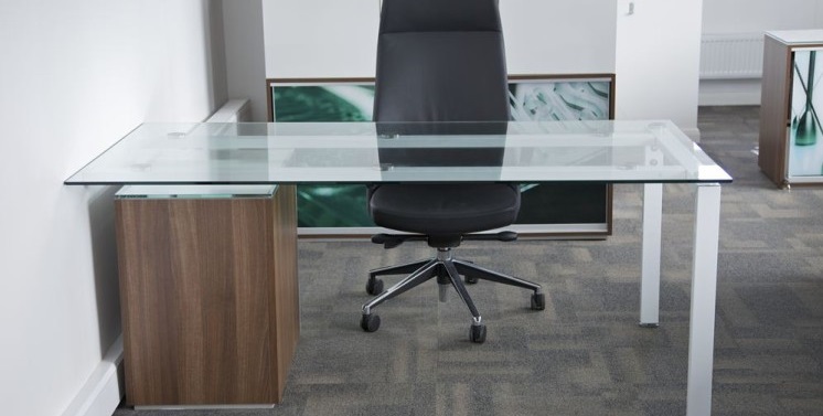 glass desk with black office chair and walnut desk pedestal