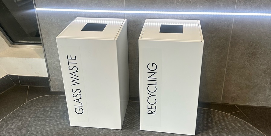 2 white office recycling bins with black lettering glass waste and recycling