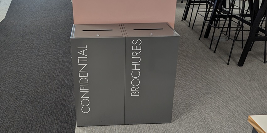 2 office recycling bins in office. Grey Bins one lockable