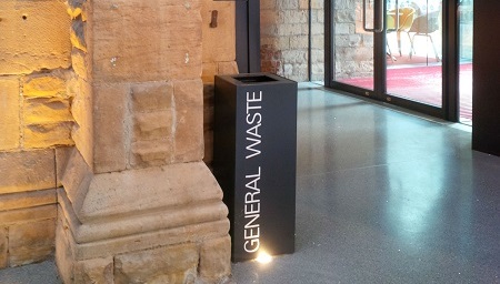 black office recycling bin with white lettering General Waste in theatre reception