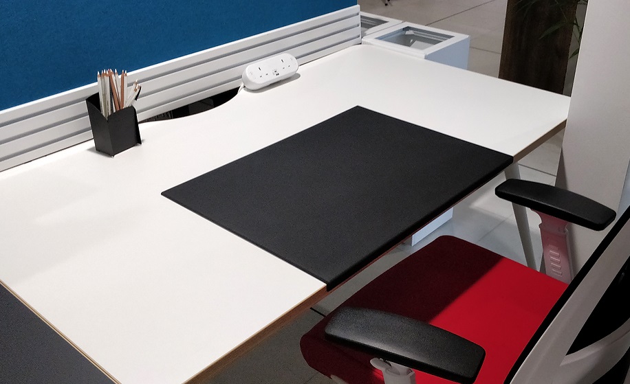 black desk pad on white desk with office chair