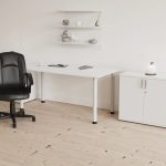 medium back executive office chair black in front of white home office desk and office cupboard