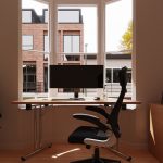 mesh back office chair black in front of desk in window of london flat