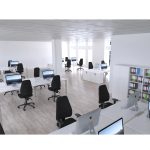 high back task operator chair in black fabric in big office with white office desks and storage