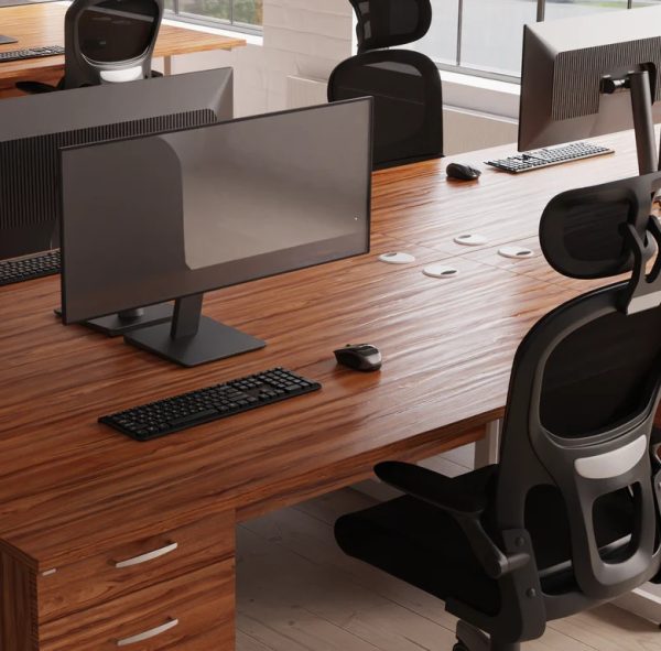 mesh back task operator chair in front of a walnut desk