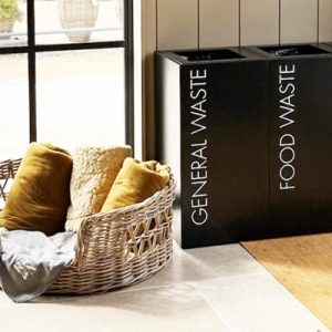 contemporary recycling bin black with white lettering in a row in cafe setting with dog basket by the side