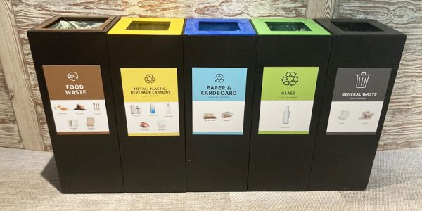 office recycling bins with coloured recycling bin tops in a row with waste stream labelling