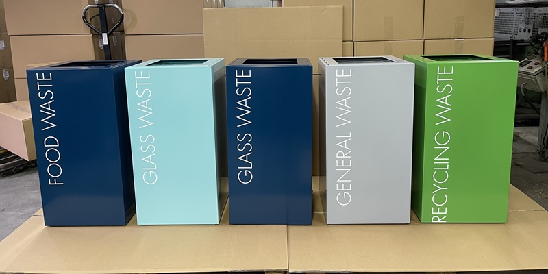 office recycling bins in different colours being packed on a pallet in a warehouse