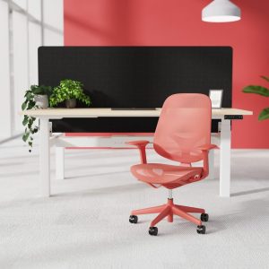 mesh back office chair in coral colour in front of office desk