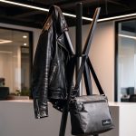 aluminium cost stand with black coat hanging on it in office
