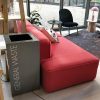 reception room shot with red reception sofa and grey office recycling bin with white lettering