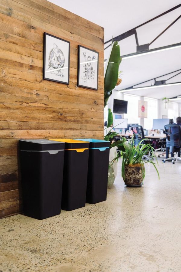 Black office recycling bins with grey, orange and blue tops for different waste