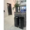 black office recycling bins with white lettering in office setting