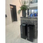 black office recycling bins with white lettering in office setting