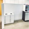 2 white office recycling bins by pigeon hole unit