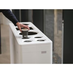 Contemporary Office Recycling bin white with multiple apertures for different waste. Someone putting cup in cup bin
