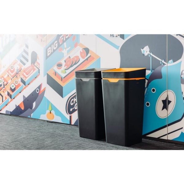 black office recycling bins in front of funky wall