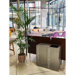 two office recycling bins in reception setting.