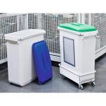 two grey office recycling bins in industrial setting. One with blue lid and one with green lid