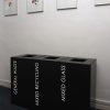 row of 3 black office recycling bins with white lettering.