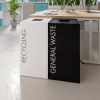 office recycling bin at side of desk. 1 black with white lettering General Waste and 1 white with black lettering Recycling