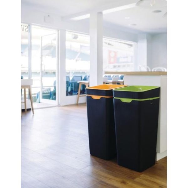 black office recycling bin with orange and green tops in cafe area