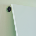close up of white message board being attatched to wall fixing
