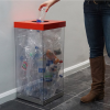 transparent office recycling bin full with plastic bottles with red top and someone placing a bin in the top.