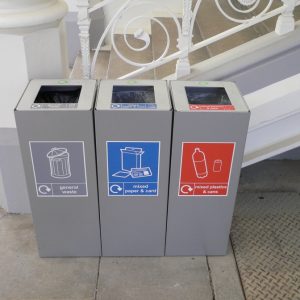 row of silver office recycling bins with labels