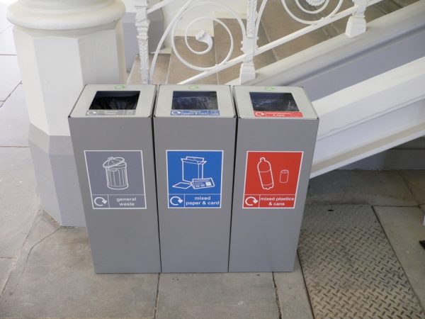 row of silver office recycling bins with labels
