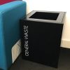 small office recycling bin black with white lettering General Waste by side of sofa