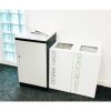 2 office recycling bins white by photocopier. 1 with Black lettering general Waste and 1 green lettering Mixed Recycling